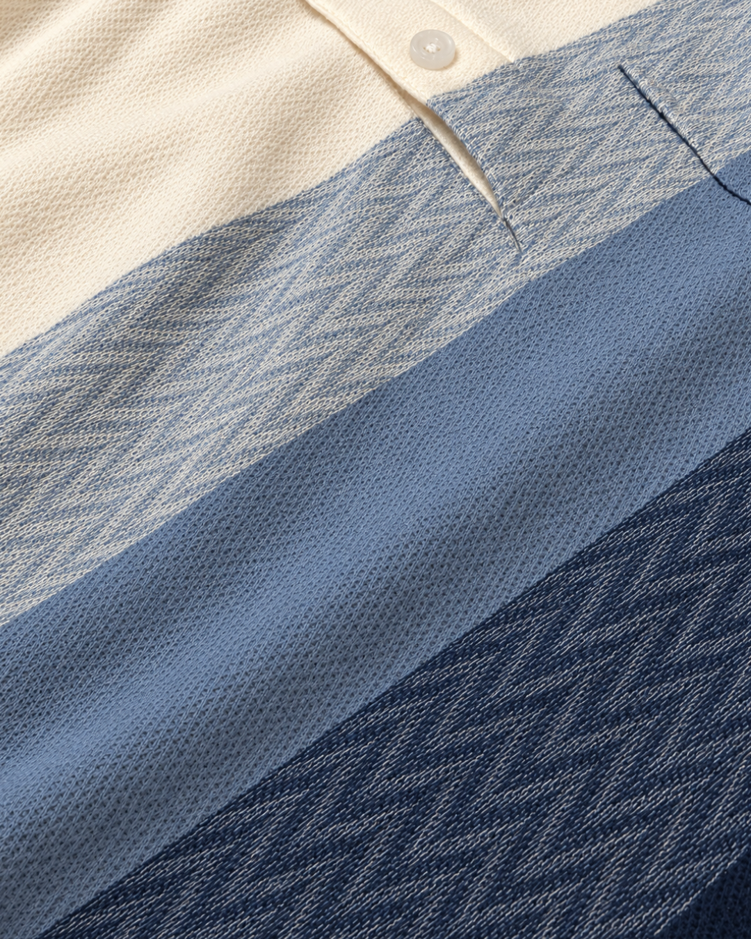 Close-up of The Ombre Stripes Designer Polo fabric in Saturn Blue, showing jacquard chevron knit and piqué-style stripes