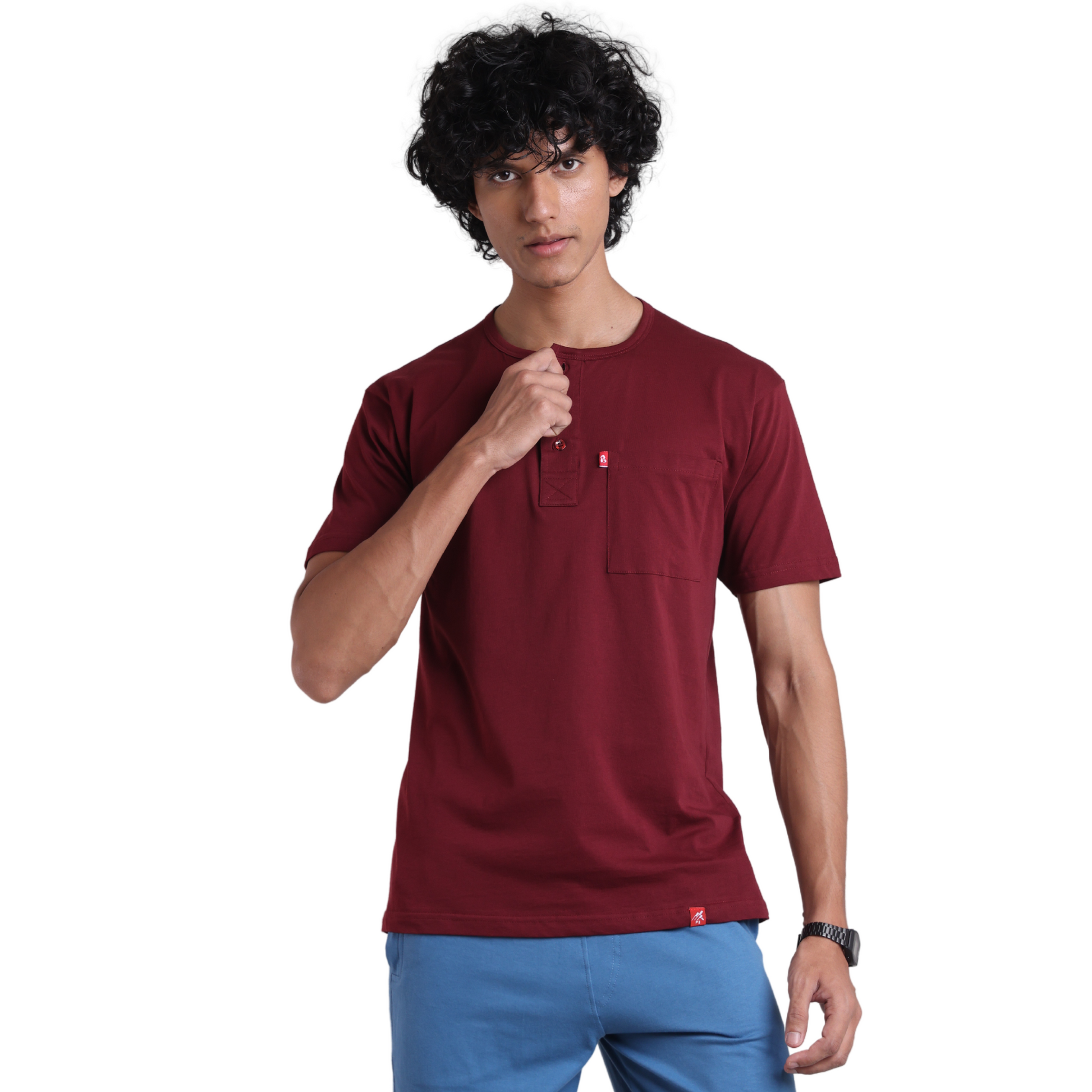 A man wearing a beige Henley shirt with short sleeves and a collar, paired with light gray trousers.