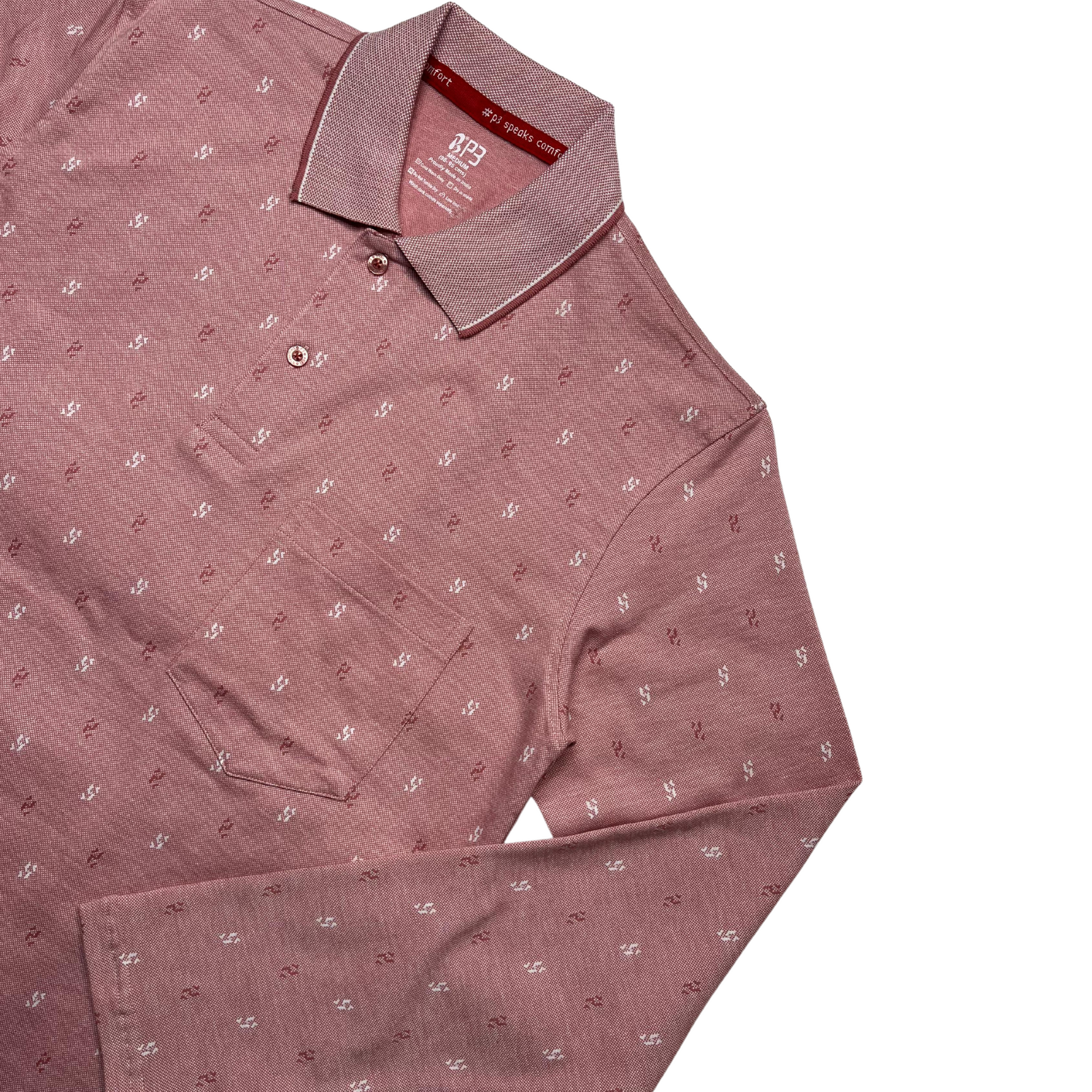 A green designer polo shirt with a pattern of small, white geometric shapes and a two-button placket.