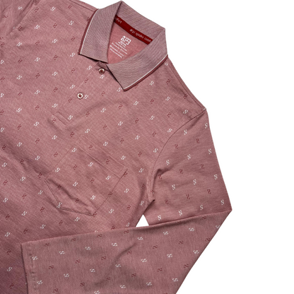 A green designer polo shirt with a pattern of small, white geometric shapes and a two-button placket.