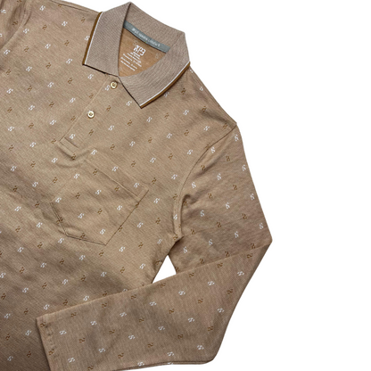 A green designer polo shirt with a pattern of small, white geometric shapes and a two-button placket.