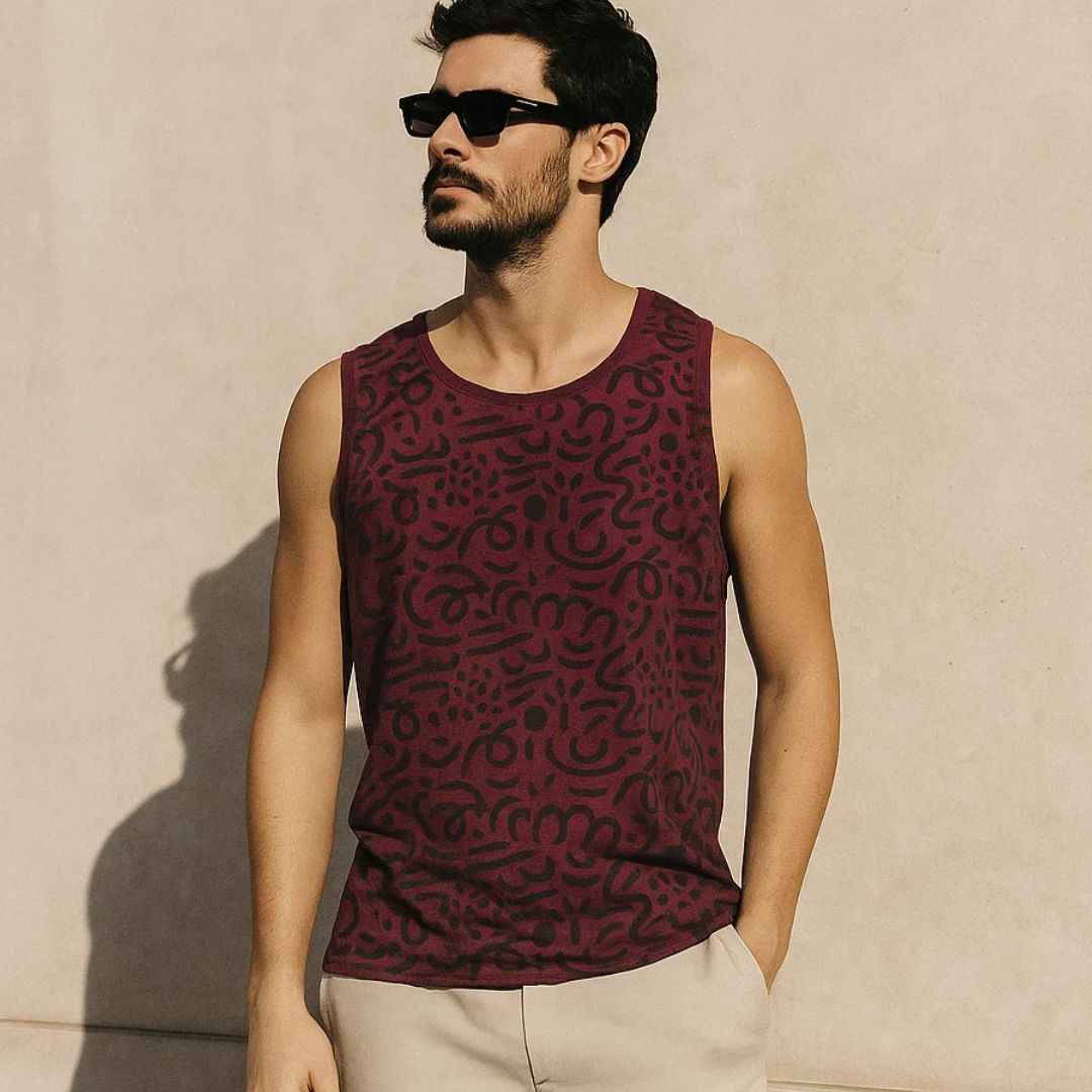 Man wearing a patterned sleeveless shirt against a beige wall