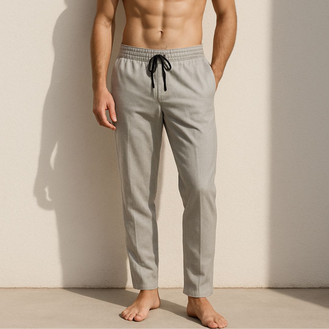Man wearing light gray pants with a drawstring against a plain background