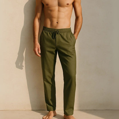 Man wearing olive green pants against a beige wall